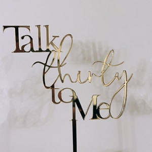 May include: Gold glitter cake topper with the text "Talk thirty to me".