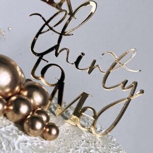 May include: White cake with gold cake topper that says "Talk Thirty To Me". The cake is decorated with gold and white frosting and has gold ball decorations.