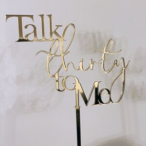 May include: Gold mirrored acrylic cake topper with the text "Talk Thirty to Me".