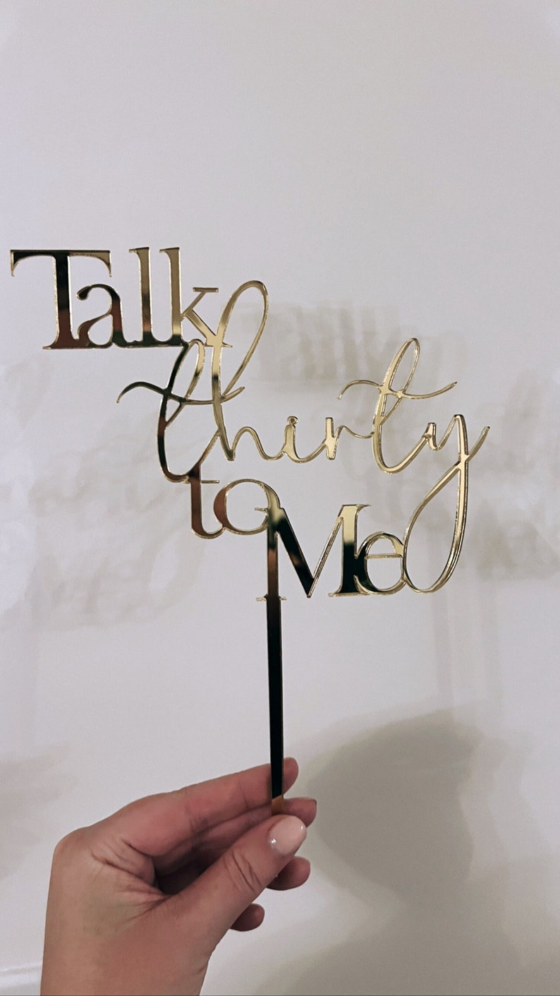 May include: Gold glitter cake topper with the text "Talk thirty to me".
