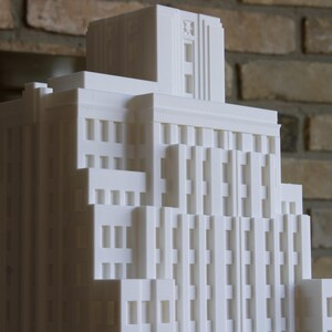 Peut inclure: Modèle blanc d'un immeuble haut avec de nombreuses fenêtres. Le bâtiment a un design simple et moderne.