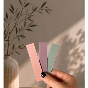 May include: Three rectangular strips in shades of pottery red, berry, and eucalyptus green. The text "Unsere &Auml;sthetics" and "POTTERY RED - BERRY - EUCALYPTUSGR&Uuml;N" appears above the strips. The strips are held together in a fan-like arrangement.