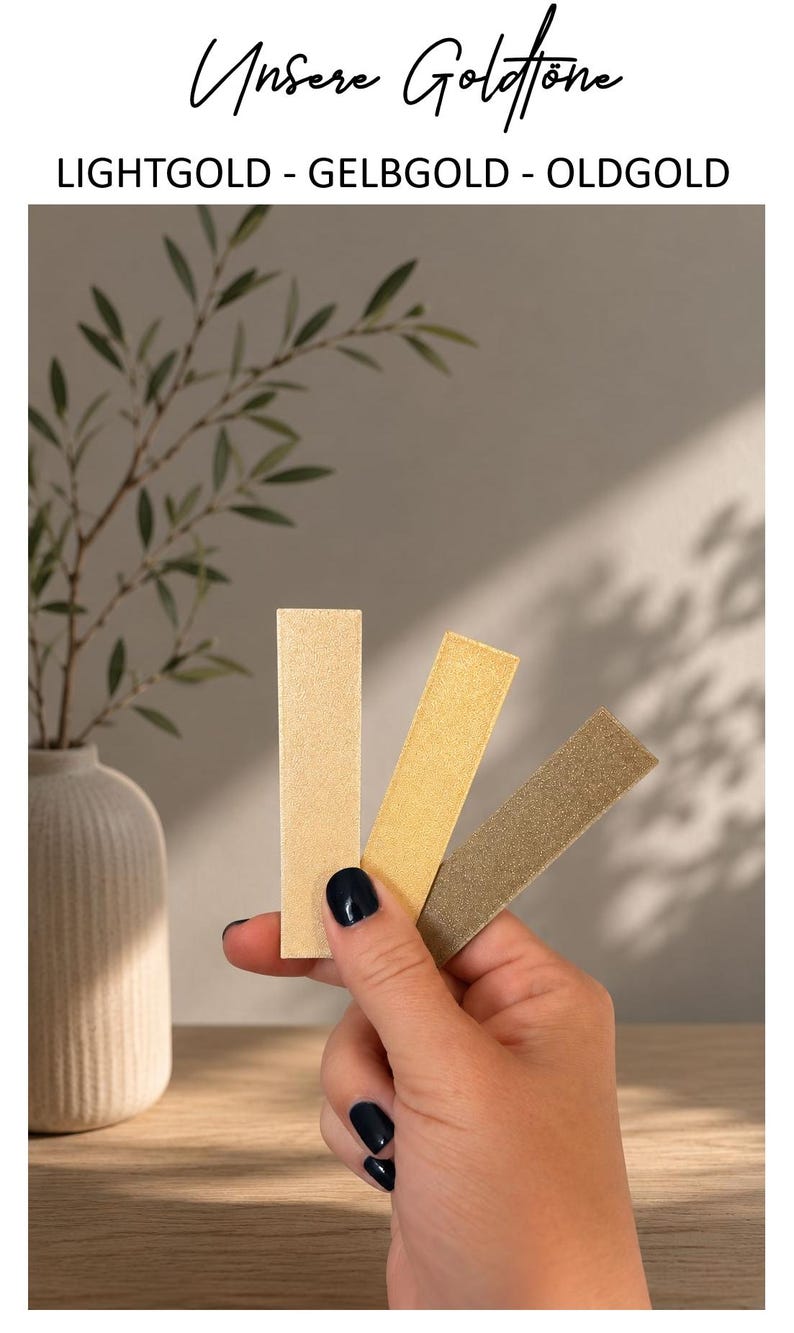 May include: Three rectangular swatches in varying metallic shades of light gold, yellow gold, and old gold. The text above the swatches reads "Unsere Goldt&ouml;ne" followed by "LIGHTGOLD - GELBGOLD - OLDGOLD" in black capital letters.