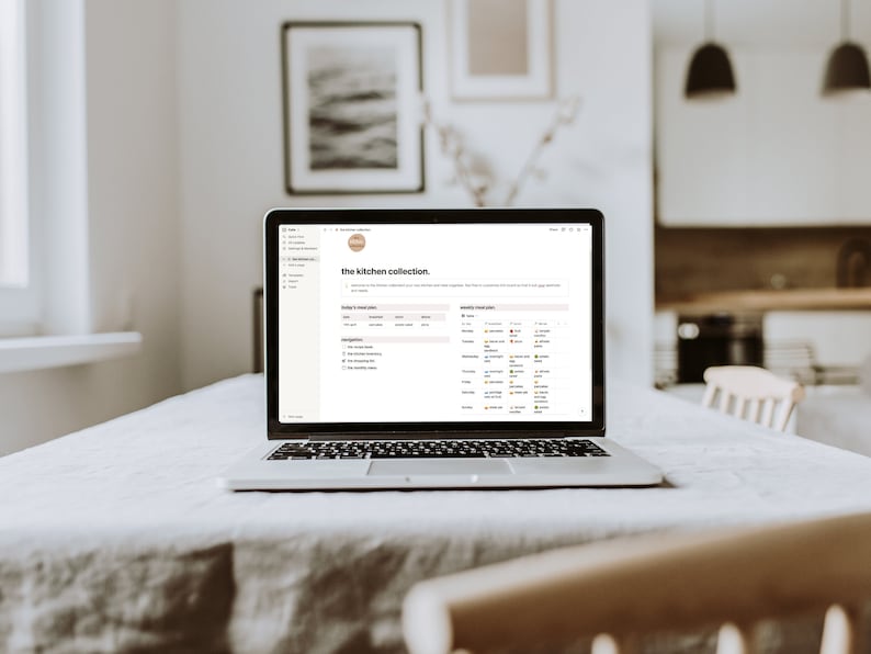 May include: A laptop computer open to a webpage titled "the kitchen collection". The page has a list of items and a calendar with dates and coloured dots.