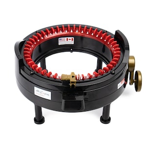 May include: A black circular knitting machine with red needles and a gold knob. The machine has a base with three legs and a label that reads "add-Express Kingsize".