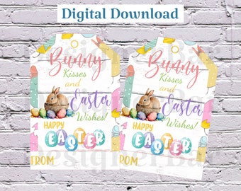 Könnte beinhalten: Zwei druckbare Ostergeschenkanhänger mit weißem Holzmaserungshintergrund. Die Anhänger zeigen ein Kaninchen, Ostereier und den Text "Bunny Kisses and Easter Wishes!"  Frohe Ostern ist in einer bunten Schrift am unteren Rand jedes Anhängers geschrieben.