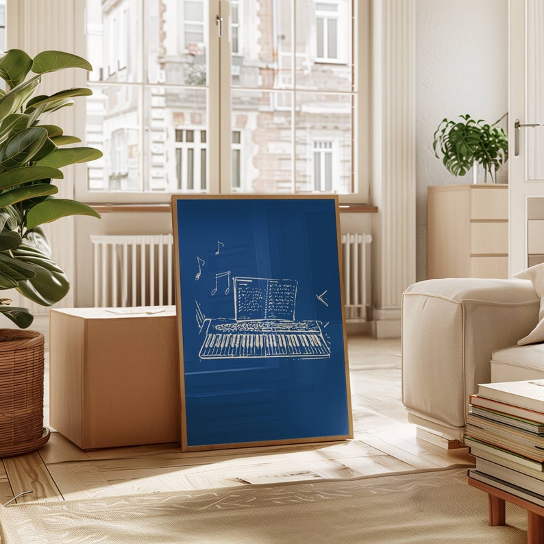 May include: A framed blue canvas print with a white outline of a keyboard and sheet music. The print is hanging on a wall in a room with a couch and a window.
