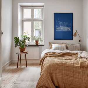 May include: A bedroom with a brown bedspread, white and brown striped pillows, and a blue framed print of a keyboard with musical notes above it.