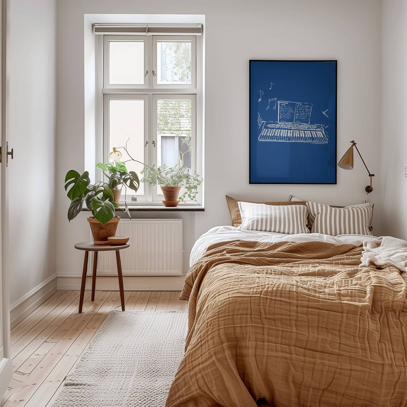 May include: A bedroom with a brown bedspread, white and brown striped pillows, and a blue framed print of a keyboard with musical notes above it.