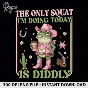 May include: A graphic design featuring a green frog wearing a pink cowboy hat, vest, and boots, holding a coffee cup. The text reads THE ONLY SQUAT I'M DOING TODAY IS DIDDLY. Accents include a cactus, horseshoe, sheriff star, and a revolver.