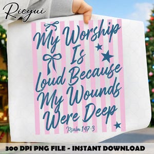 Op de afbeelding: Een witte print met roze verticale strepen en de blauwe tekst "My Worship Is Loud Because My Wounds Were Deep". De tekst bevat ook "Psalm 147:3". De print wordt door een persoon vastgehouden.