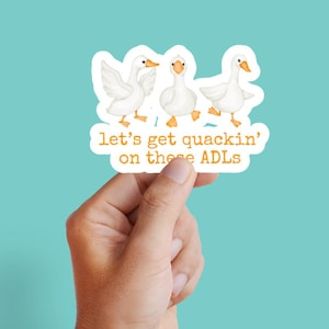 May include: A sticker showing three white cartoon geese with orange beaks and feet. The geese are in different poses, with one flapping its wings. The sticker has the text "let's get quackin' on these ADLs" in orange.