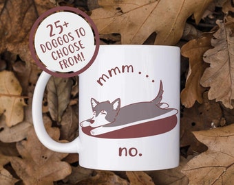 Puede incluir: Taza de cerámica blanca con un perro de dibujos animados. El perro es gris y blanco y está acostado de espaldas con las patas en el aire. La taza tiene el texto "mmm... no."