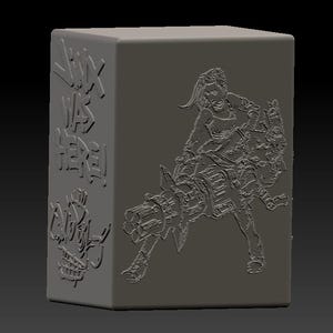 May include: A gray, rectangular block with embossed artwork. One side reads "Jinx Was Here!" with a skull graphic. The other side features a detailed image of a character with a large weapon. The overall design has a 3D effect.