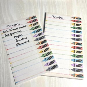 May include: Two to-do list notepads with colorful crayon illustrations. The notepads have lined pages with the heading "To-Do:" and a list of items including "Go to Farmer's market" and "Buy groceries."
