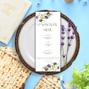 Può includere: Un menu di Pasqua con illustrazioni di rami d'ulivo è su un piatto decorativo. Il menu elenca antipasti, piatti principali e dessert. Sono presenti anche un rametto di lavanda e matzah.