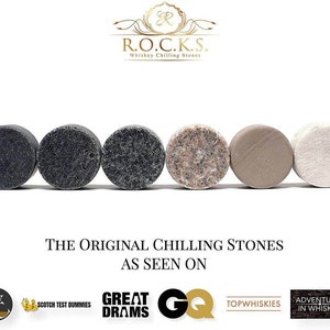 May include: Five round whiskey chilling stones in various colors, including black, gray, pink, beige, and white. The stones are arranged in a row on a white surface. The text "THE ORIGINAL CHILLING STONES AS SEEN ON" is below the stones.  Logos for Scotch Test Dummies, Great Drams, GQ, Top Whiskies, and Adventures in Whiskey are below the text.