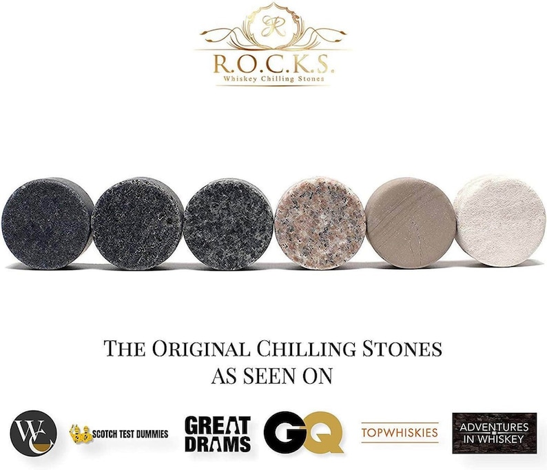 May include: Five round whiskey chilling stones in various colors, including black, gray, pink, beige, and white. The stones are arranged in a row on a white surface. The text "THE ORIGINAL CHILLING STONES AS SEEN ON" is below the stones.  Logos for Scotch Test Dummies, Great Drams, GQ, Top Whiskies, and Adventures in Whiskey are below the text.