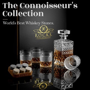 May include: A set of whiskey stones, a decanter, and four glasses with a diamond pattern. The set is on a black surface with a box that says "World's Best Whiskey Stones." and "R.O.C.K.S. Whiskey Chilling Stones."