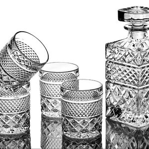 May include: A set of four clear glass tumblers and a clear glass decanter with a diamond pattern. The decanter has a stopper.