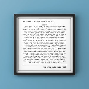 May include: A framed print featuring a scene from "The Devil Wears Prada" (2006). The text, in a typewriter-style font, details a monologue about the color cerulean. The frame is black, and the background is a light blue.