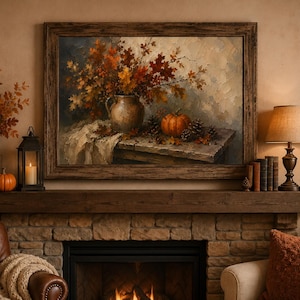 May include: A framed oil painting depicting a rustic still life scene with a ceramic pitcher filled with autumn leaves, a single orange pumpkin, and pinecones resting on a wooden table, rendered in warm, textured brushstrokes of brown and gold.