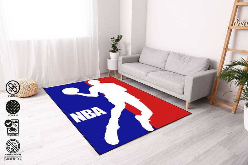May include: A blue and red rug with the NBA logo and a basketball player silhouette. The logo says "NBA".
