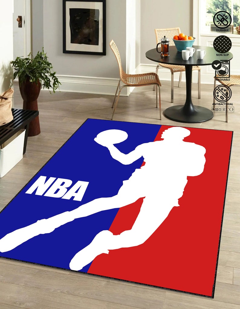 May include: A blue and red rug with the NBA logo and a silhouette of a basketball player. The logo says "NBA" in white letters.