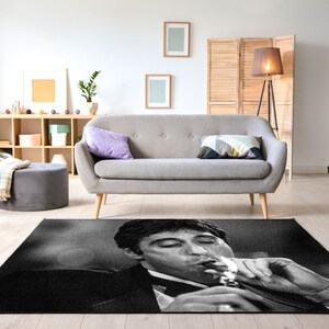 May include: Black and white rug featuring a close-up image of a man smoking a cigarette. The man is wearing a suit and has a serious expression on his face.