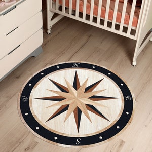 May include: A round, black and white compass rug with a wooden design. The rug features a compass rose with the letters N, S, E, and W. The rug is perfect for a nursery or playroom.