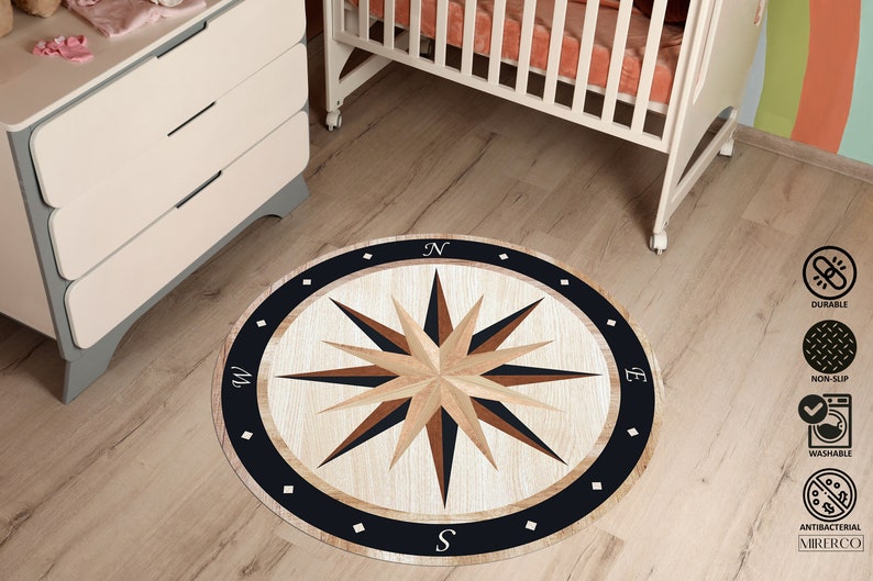 May include: A round, black and white compass rug with a wooden design. The rug features a compass rose with the letters N, S, E, and W. The rug is perfect for a nursery or playroom.