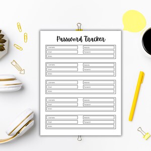 Password tracker page clipped at the top, centered on a white desk and surrounded by yellow office supplies, paper clips, a pen, a cup of black coffee, and a small plant.