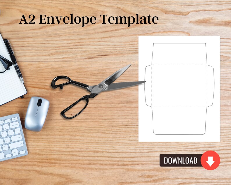 Envelope template displayed on a wood desk with scissors, a keyboard, and a notepad, showing solid and dotted cut-and-fold outlines.