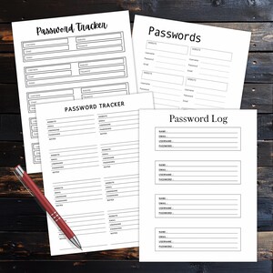 Four black and white password organizer pages labeled Password Tracker, Passwords, Password Log, and Password Tracker arranged on a dark wooden surface with a red pen.