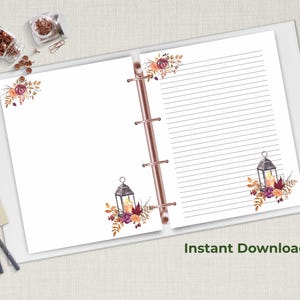 Fall stationery set with lantern and floral design displayed inside a rose gold binder, featuring lined and unlined pages, with cozy autumn theme.
