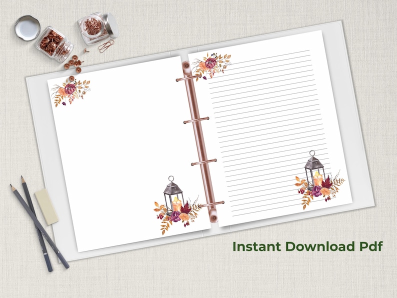 Fall stationery set with lantern and floral design displayed inside a rose gold binder, featuring lined and unlined pages, with cozy autumn theme.