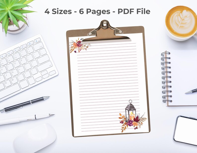 Fall stationery sheet with floral lantern design on a clipboard, surrounded by keyboard, coffee, and office supplies.