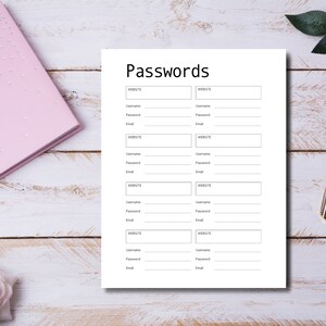 Open ring-bound planner displaying password pages labeled “Passwords” and “Password Tracker,” styled on a light surface with gold clips, decorative leaves, scattered confetti, and a pen.