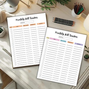 Two monthly bill tracker sheets with colorful header sections displayed on a bright desk alongside pencils, plants, and small office accessories.