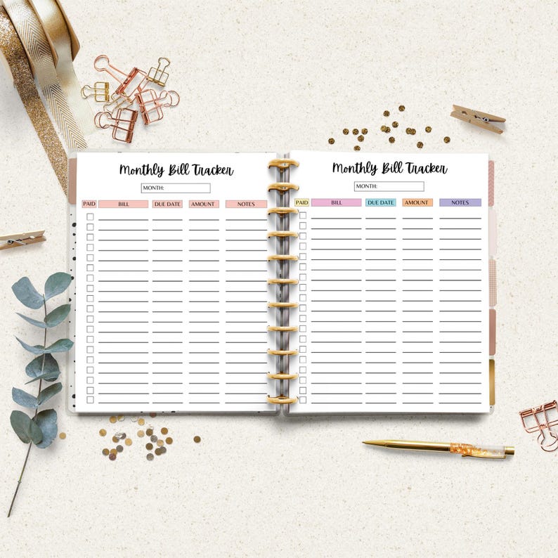 Monthly bill tracker displayed inside a planner style binder on a neutral desk background.