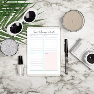 Get away list planner page displayed on a tablet on a marble desk with sunglasses, camera, pen, candle, and tropical leaves, showing vacation planning sections.
