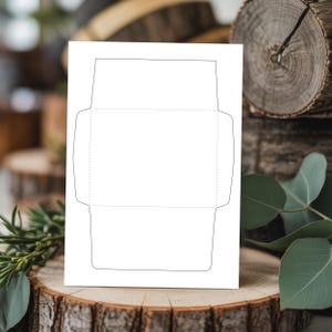 Envelope template displayed upright on a tree stump with wood slices and greenery in the background, showing solid cut lines and dotted fold lines.