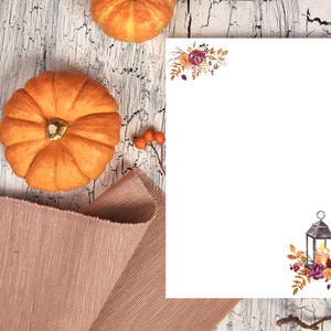 Fall writing paper with lantern and floral design, featuring autumn pumpkins and rustic wood background for seasonal stationery.