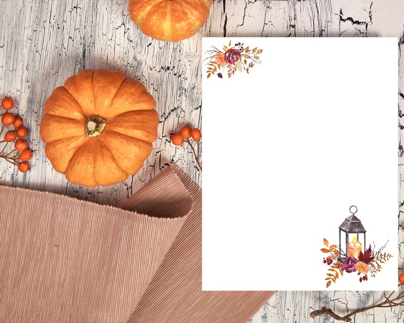 Fall writing paper with lantern and floral design, featuring autumn pumpkins and rustic wood background for seasonal stationery.