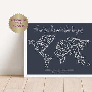 May include: A framed world map print with a geometric design in white against a dark blue background. The text "And so, the adventure begins" is at the top. The names Darren, Felicity, Mia & Marcus are listed below the map, with "Travel Adventures" underneath.