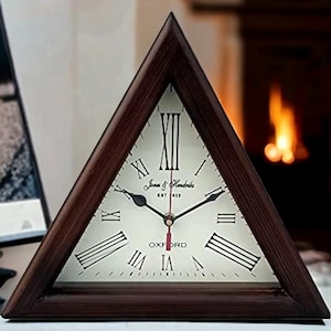 Puede incluir: Un reloj de madera triangular con números romanos y una esfera blanca. La esfera del reloj dice "Jones & Hendricks Est 1923 Oxford".
