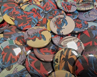 Puede incluir: Una colección de botones redondos coloridos con ilustraciones de cómics de un superhéroe con un traje rojo y negro. Los botones están dispuestos en un patrón aleatorio y algunos de los botones tienen el texto "CONSUME THIS, JEREMY".