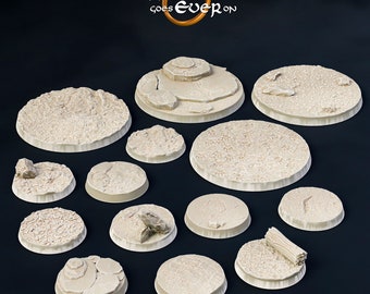 May include: A collection of thirteen circular beige miniature bases with varied terrain textures including rocky outcrops, cracked earth, and a fallen log. The text "the PRINTING goes EVER on" is displayed at the top in white and gold lettering.