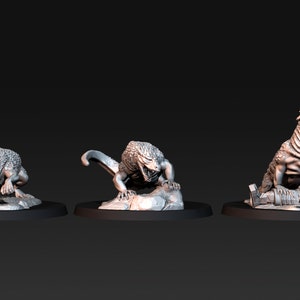 Puede incluir: Tres figuras en miniatura de criaturas fantásticas, cada una con una pose y una expresión diferentes. Las criaturas están hechas de un material gris claro y parecen estar esculpidas en un estilo realista.