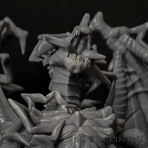 May include: A grey resin miniature figure of a multi-headed dragon with sharp teeth, textured scales, and large wings. The creature features an open mouth and intricate spikes along its body. The text 16K Ultra Detail is visible at the bottom.